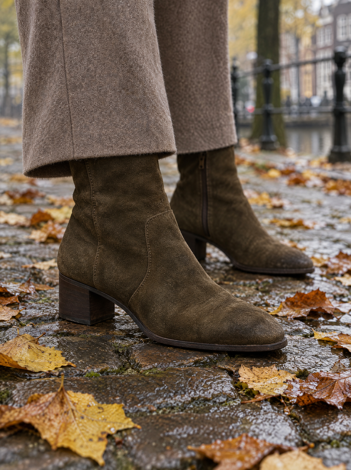 Suede enkellaarsjes in olijfbruin op natte kasseien met herfstbladeren